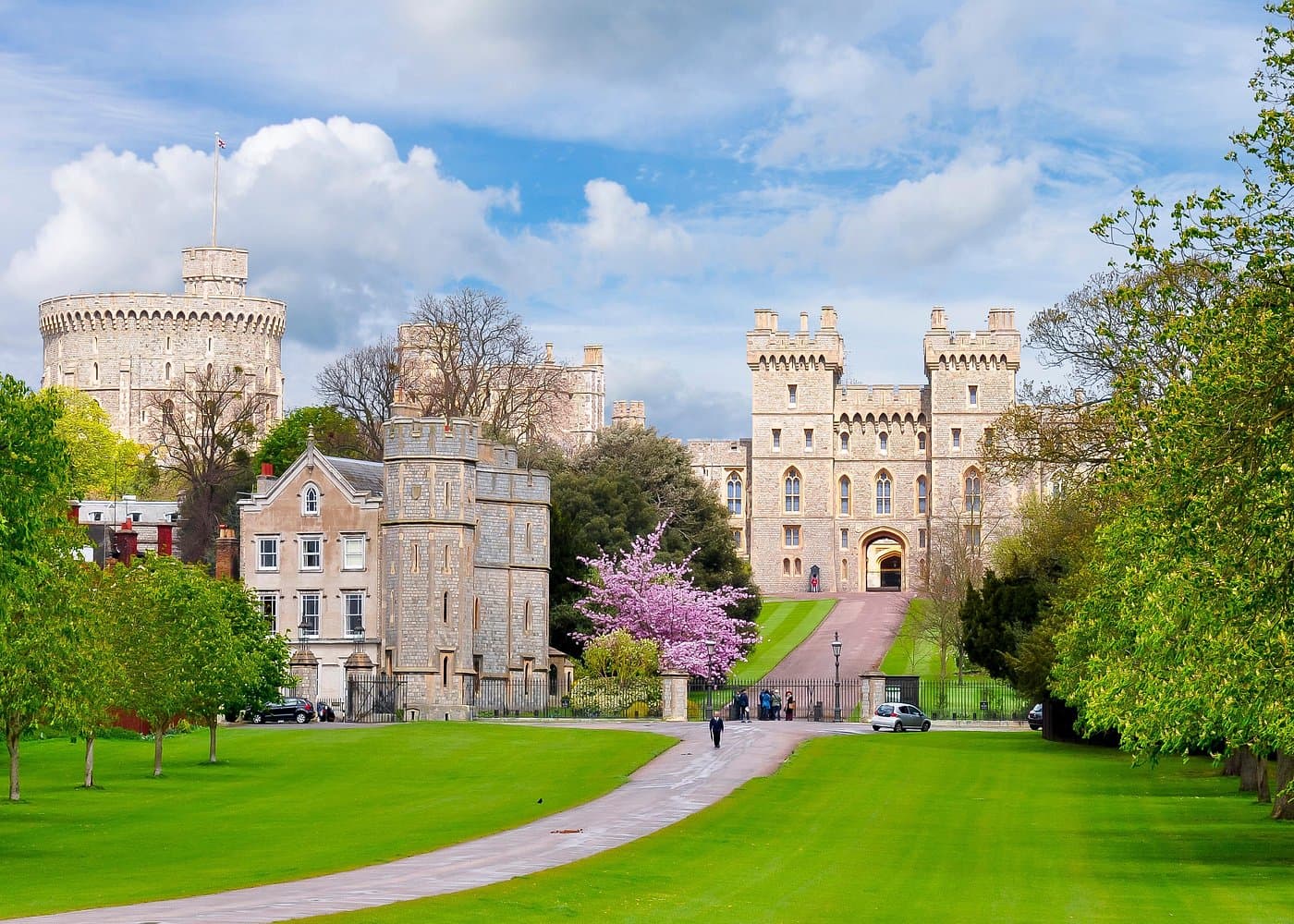 Windsor Castle across a green lawn, with the Round Tower and gatehouse under a blue sky.